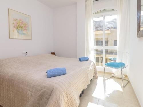 a bedroom with a bed and a chair and a window at Apartment Montanar Luz by Interhome in Jávea