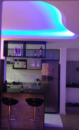 a kitchen with a refrigerator and a bar with stools at Perto Aeroporto Salgado Filho e Arena do Grêmio in Porto Alegre