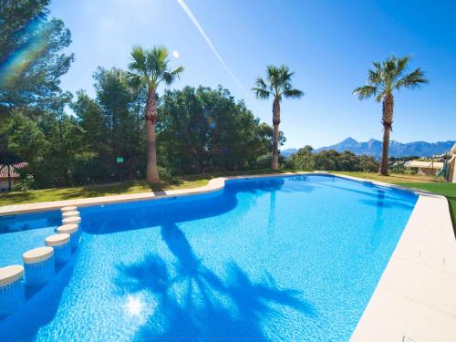 una piscina con palmeras y montañas al fondo en Apartment Villa Marina Golf-1 by Interhome, en Altea la Vieja
