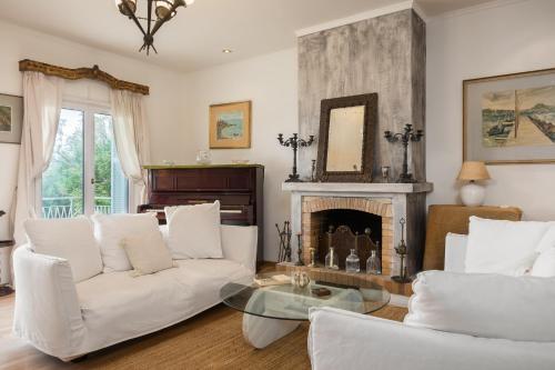 a living room with white furniture and a fireplace at Classy lux apt w/ sea view, garden, parking in Corfu