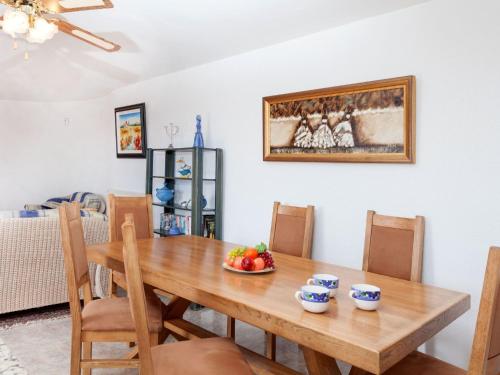 a dining room with a wooden table with a bowl of fruit at Holiday Home Lausanne by Interhome in Calonge