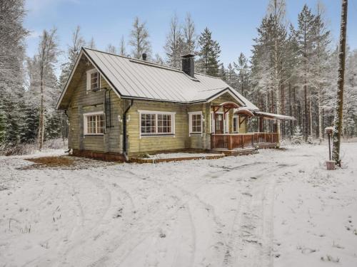 uma pequena casa de madeira na neve na floresta em Holiday Home Josala by Interhome em Ruokomäki