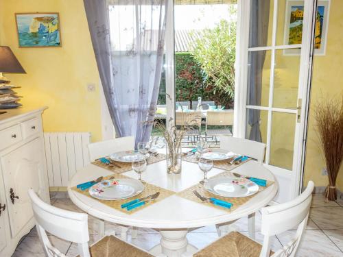 サン・パレ・シュル・メールにあるHoliday Home Les Grillons by Interhomeのダイニングルーム(白いテーブル、白い椅子付)