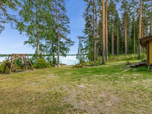 uma área de piquenique com um baloiço e água em Holiday Home Rantapirtti by Interhome em Niskamäki