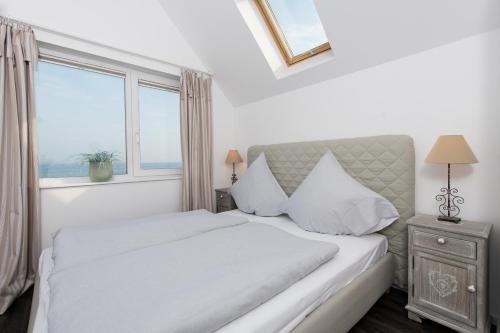 een witte slaapkamer met een groot bed en een raam bij Möwenblick in Olpenitz
