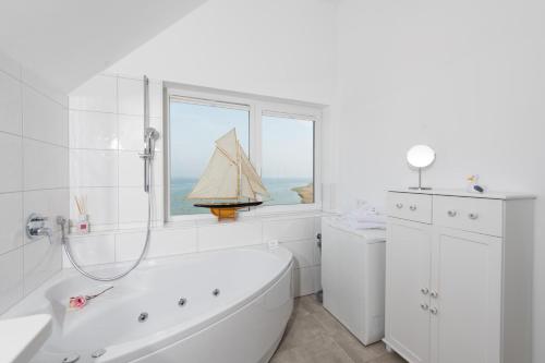 a white bathroom with a sail boat on the window at Möwenblick in Olpenitz