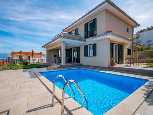 a villa with a swimming pool in front of a house at Villa Vali 1 by Interhome in Vrbnik