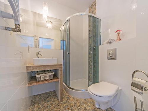 La salle de bains blanche est pourvue d'une douche et de toilettes. dans l'établissement Apartament Kameralny 65 na Starówce, à Gdańsk
