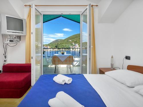 a bedroom with a bed and a balcony with a table at Apartment Rubin-11 by Interhome in Selca kod Bogomolja