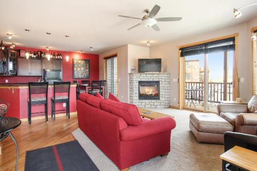 a living room with a red couch and a fireplace at Nakai Peak 41B Condo in Estes Park