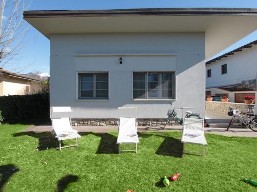 eine Gruppe von Stühlen im Gras vor einem Haus in der Unterkunft Villa Matteo by Interhome in Forte dei Marmi