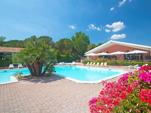 una piscina in un resort con fiori rosa di Holiday Home Gineprino-10 by Interhome a Marina di Bibbona