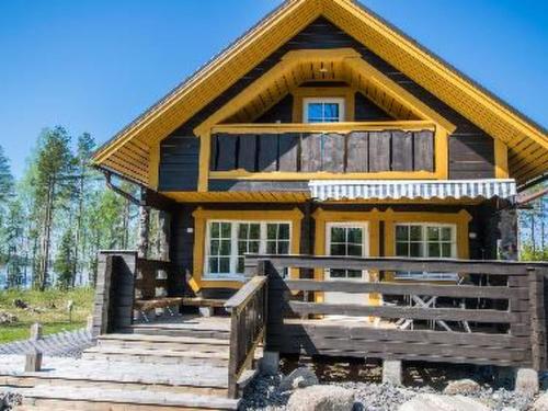 a house with a porch and stairs in front of it at Holiday Home Runopuro by Interhome in Kerkonjoensuu