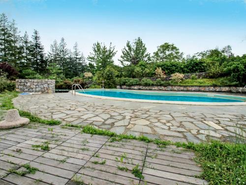 a swimming pool in a landscaped yard with a stone patio at Holiday Home Carlotta by Interhome in Soviore