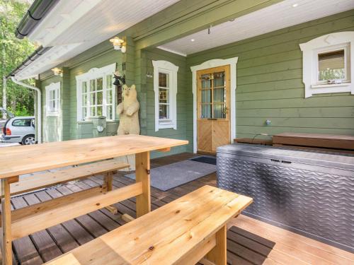 um alpendre com uma mesa de madeira e um banco em Holiday Home Isoniemi by Interhome em Suinula