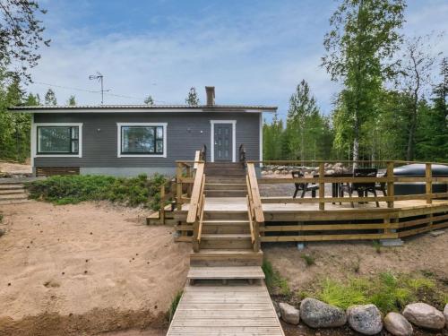 a house with a wooden bridge leading to a house at Holiday Home Tähtiranta by Interhome in Valkeala