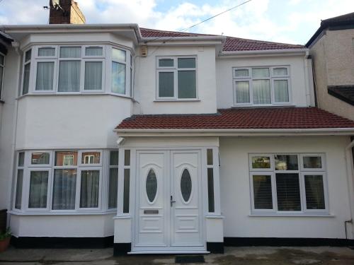 uma casa branca com portas e janelas brancas em Apple House Wembley em Barnet
