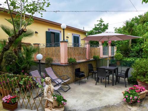 eine Terrasse mit einem Tisch, Stühlen und einem Sonnenschirm in der Unterkunft Holiday Home Il Piccolo Nocelleto by Interhome in SantʼAgata sui Due Golfi