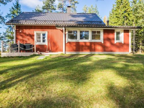 una casa roja con un gran patio delante en Holiday Home Kannonniemi by Interhome en Majavesi