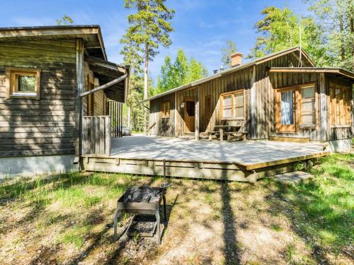 uma cabana de madeira com um deque e uma casa em Holiday Home Lauhanlinna by Interhome em Isojoki
