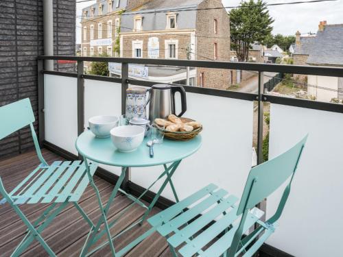 - une table sur un balcon avec 2 chaises et un bol de pain dans l'établissement Apartment Roc Eden-1 by Interhome, à Saint-Malo