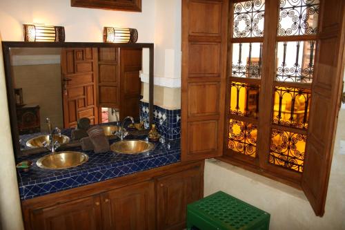 a bathroom with two sinks and a mirror at Riad Zanzibar in Marrakech