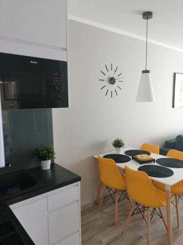 a kitchen with a table with chairs and a microwave at Apartament Mateusz in Świnoujście