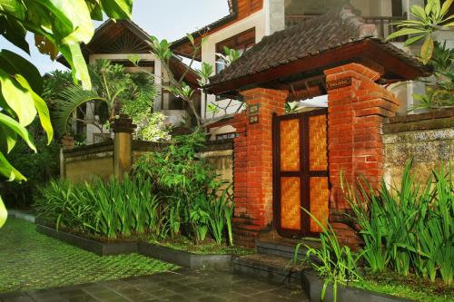a brick house with a garden in front of it at Bali Ayu Hotel & Villas in Seminyak