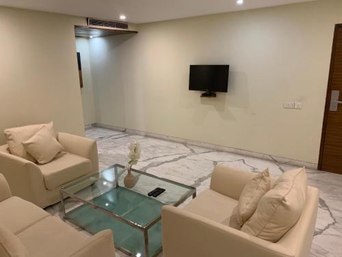a living room with two couches and a tv at The Manohar Hyderabad in Hyderabad
