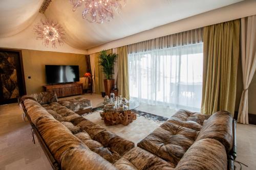 a large couch in a living room with a television at Telal Resort Al Ain in Al Ain