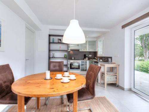uma cozinha e sala de jantar com uma mesa de madeira e cadeiras em Apartment Matthias-2 by Interhome em Llançà