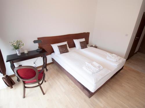 a bedroom with a bed and a desk and a chair at Dwór i Dworek Leszczowate Wellness & Spa in Ustrzyki Dolne