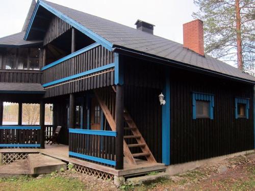 ein schwarzes Haus mit blauem Dach in der Unterkunft Holiday Home Kiviniemi by Interhome in Tohmajärvi