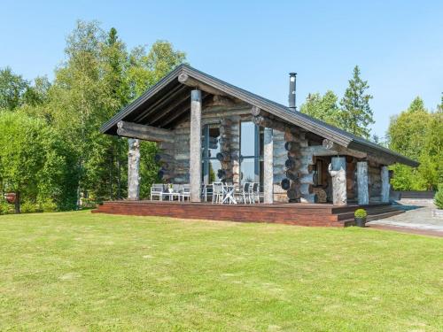 eine Blockhütte mit einem Tisch und Stühlen im Hof in der Unterkunft Holiday Home Villa pärla by Interhome in Myllykangas