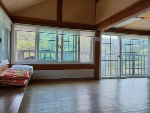 a large room with large windows and a bed in it at Tongyeong Yehyang Pension in Tongyeong
