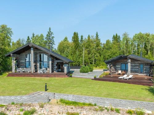 ein Blockhaus mit einem großen Garten und einer Terrasse in der Unterkunft Holiday Home Villa pärla by Interhome in Myllykangas