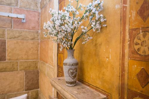 un vase avec des fleurs assis sur une table dans la salle de bains dans l'établissement Guest House Marrakech, à Gabrovo