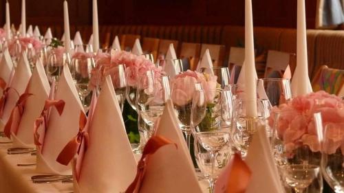 a table with wine glasses and flowers on it at Hotel Bayerischer Hof in Waldsassen