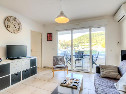 un salon avec un canapé, une télévision et une table dans l'établissement Apartment Royal Rivage-2 by Interhome, à Carqueiranne