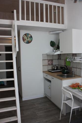 una pequeña cocina con escaleras que conducen a un loft en Neptunea Apartments, en Vladivostok