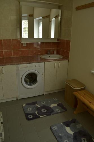 a bathroom with a washing machine and a sink at Mere Holiday House in Salme