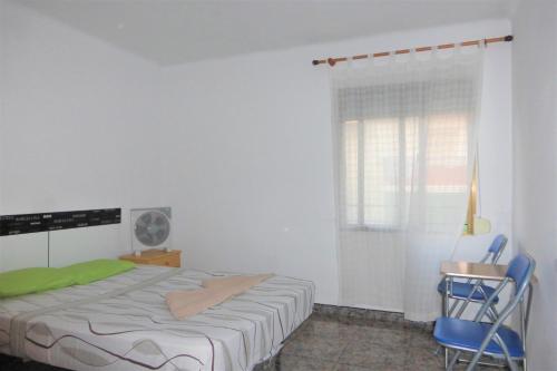 a bedroom with a bed and a chair and a window at Nice double room in Alicante in Alicante