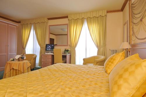 a hotel room with a yellow bed and a desk at Residence Antares in Madonna di Campiglio