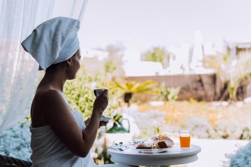 a woman sitting at a table with a plate of food at Masseria Palane in Pat&ugrave;