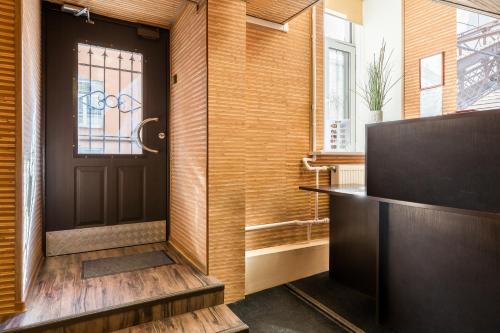 a hallway with a black door and a window at Mini Hotel na Nevskom 136 in Saint Petersburg