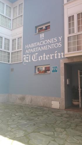 a building with a sign on the side of it at Hotel El Coterin Apartamentos y Habitaciones in Arenas de Cabrales
