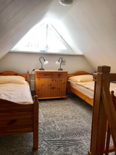 ein Dachgeschosszimmer mit zwei Betten und einem Fenster in der Unterkunft "Matrosenlogis" by Ferienhaus Strandgut in Born