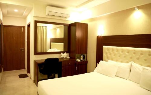 a bedroom with a bed and a desk and a mirror at Hotel Lords, Fort in Mumbai