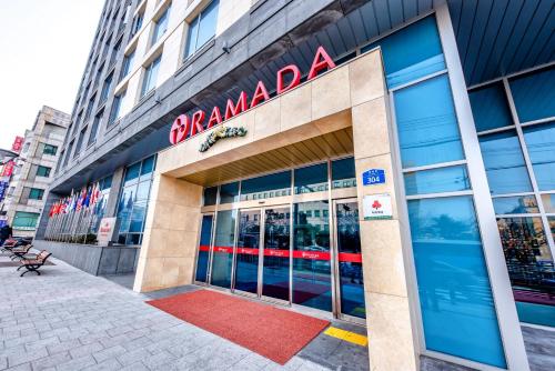a building with a sign on the front of it at Ramada by Wyndham Jeju City Hall in Jeju