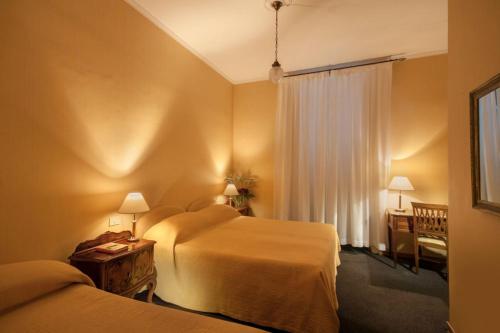 a hotel room with two beds and a desk at Orange Garden B&B in Rome
